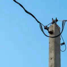 Betonowy słup energetyczny z przewodami. Dyskusja na forum o odszkodowanie za słupy energetyczne.