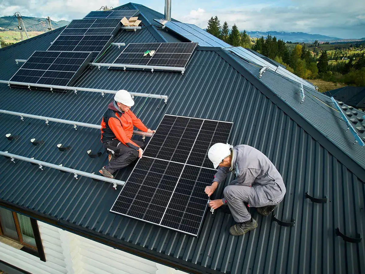 Instalacja paneli fotowoltaicznych na dachu. Pracownicy montują panele, co może być związane z pozytywnymi columbus energy opinie.