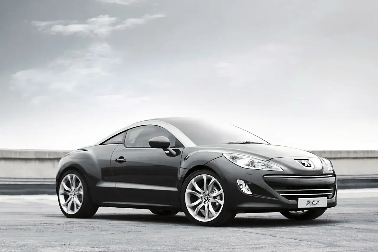 Elegancki Peugeot RCZ na tle pochmurnego nieba. Sportowy samochód z charakterystycznym dachem.