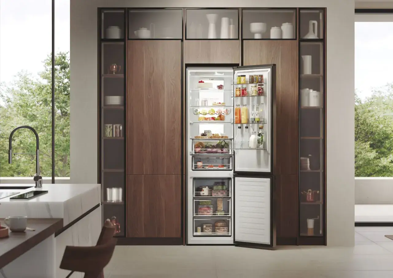 Nowoczesna kuchnia z otwartą lodówką Haier, pełną świeżych produktów i napojów. Haier to firma znana z innowacyjnych rozwiązań AGD.