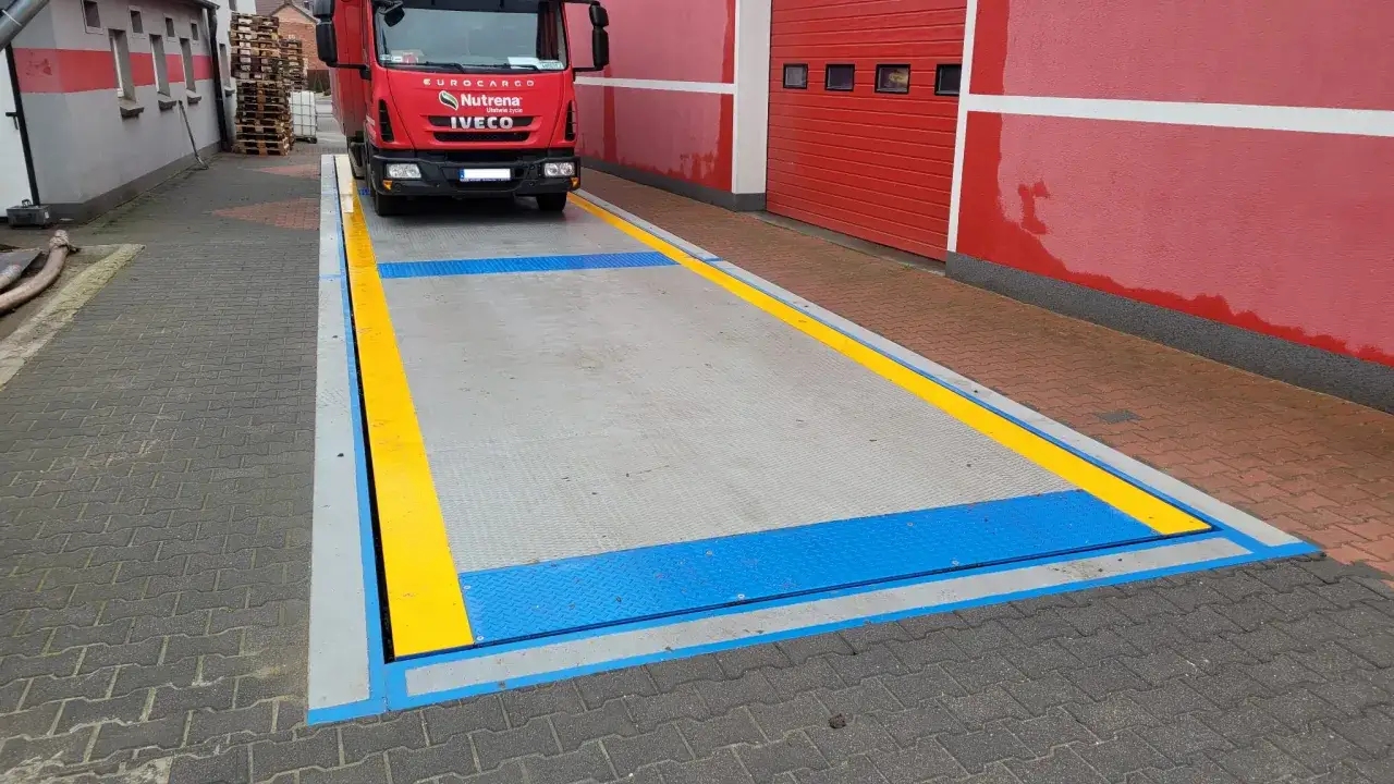 Waga samochodowa z czerwonym Iveco. Pozwala sprawdzić, ile waży m3 betonu, czy też inne materiały.