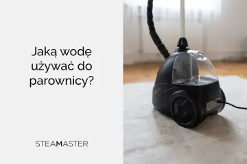 Czarna parownica z przezroczystym zbiornikiem na wodę, stojąca na dywanie.